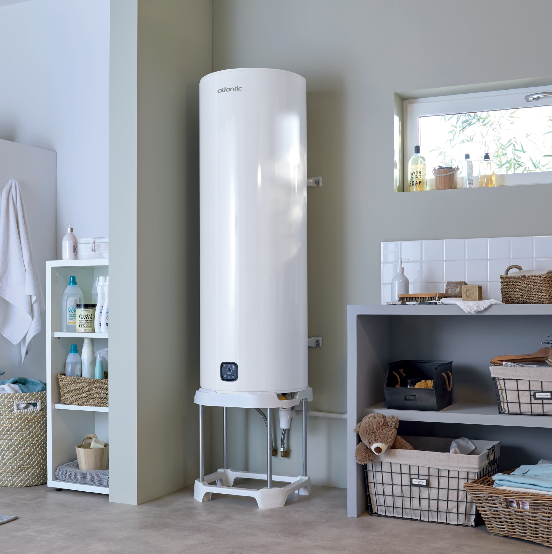 Chauffe-eau électrique Atlantic installé dans une pièce moderne avec des étagères et des paniers de rangement.