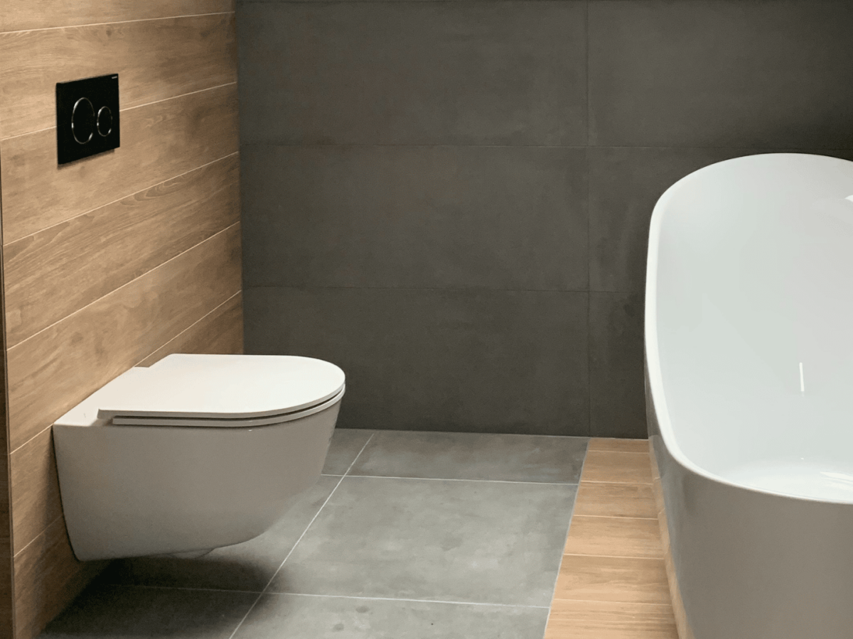 Salle de bain moderne avec WC suspendu et baignoire design.